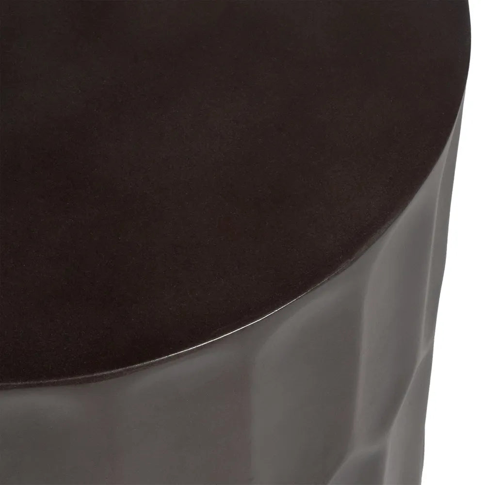 Close-up of a dark brown circular side table on a reflective surface
