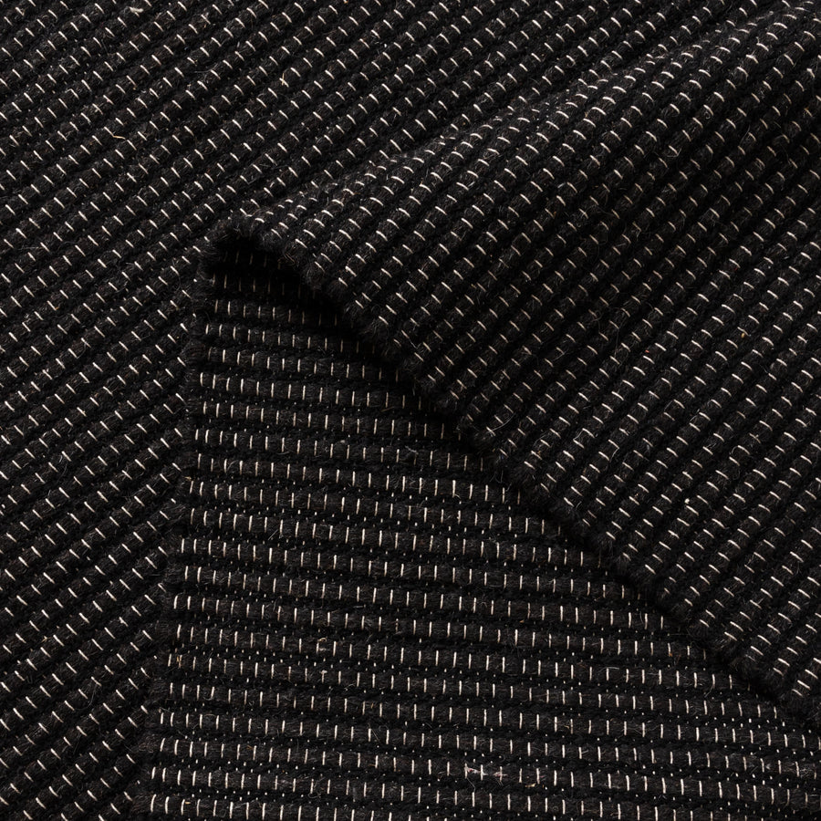 Close-up of black textured wool rug
