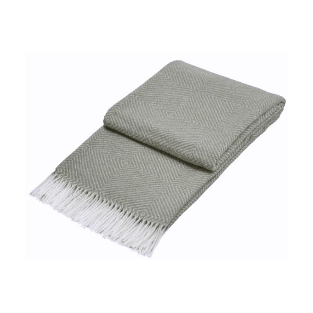 light grey folded throw rug with diamond pattern and white fringe on white background