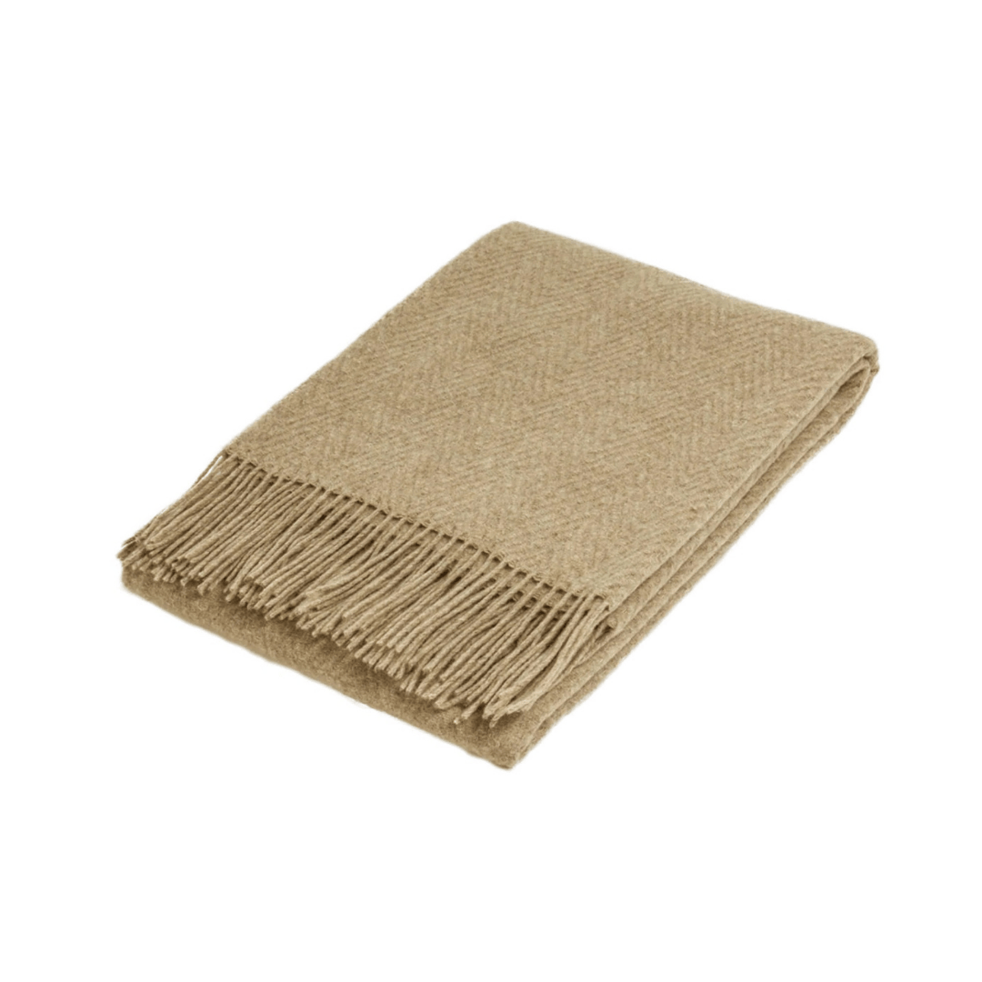 Folded camel wool throw rug with subtle self pattern on white background