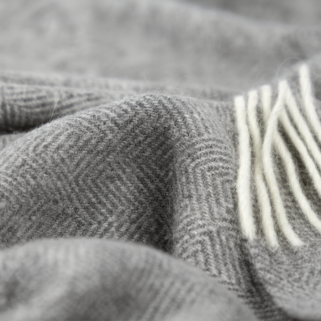 Close-up of a textured gray fabric with a bundle of white yarn.
