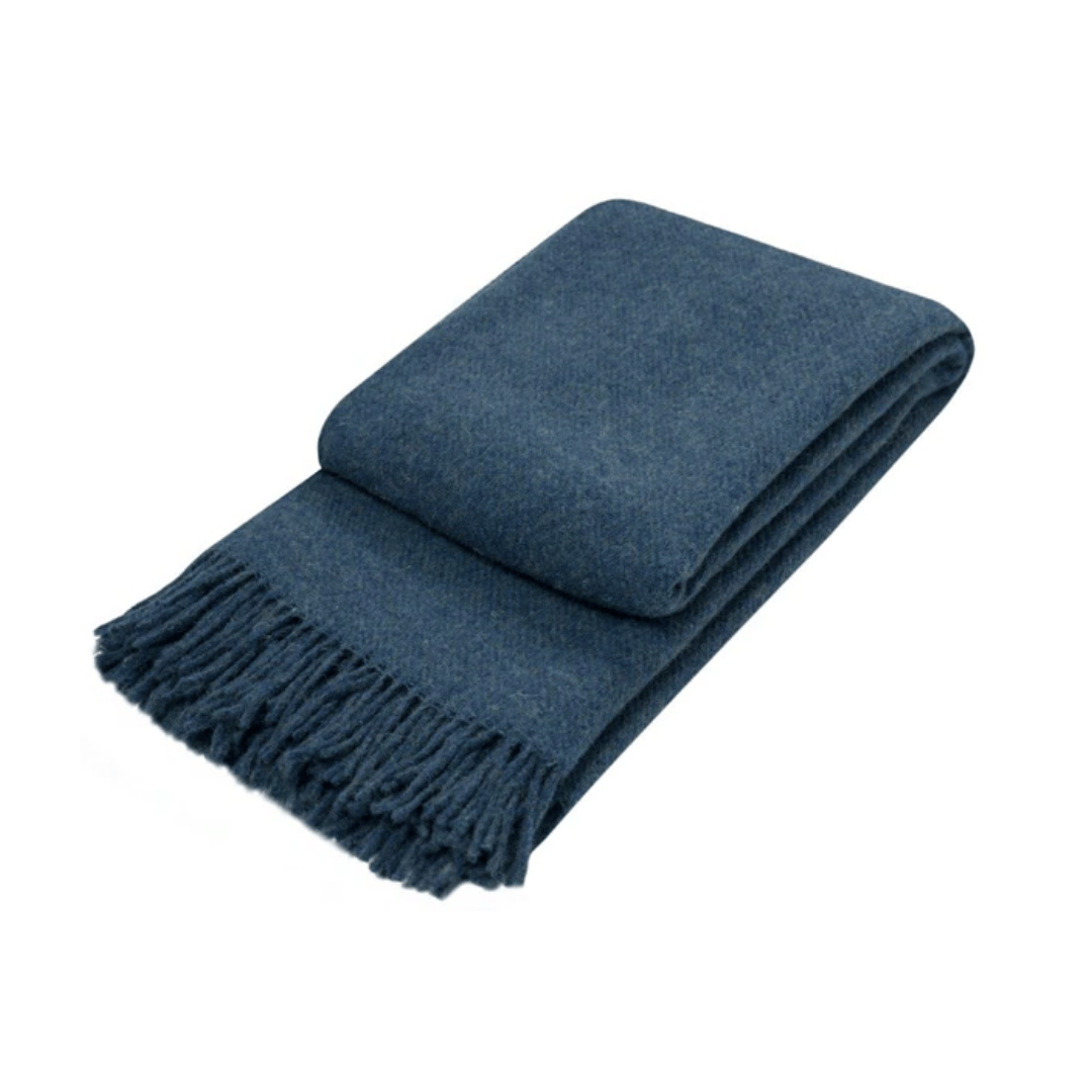 folded navy throw rug with fringe edge on white background