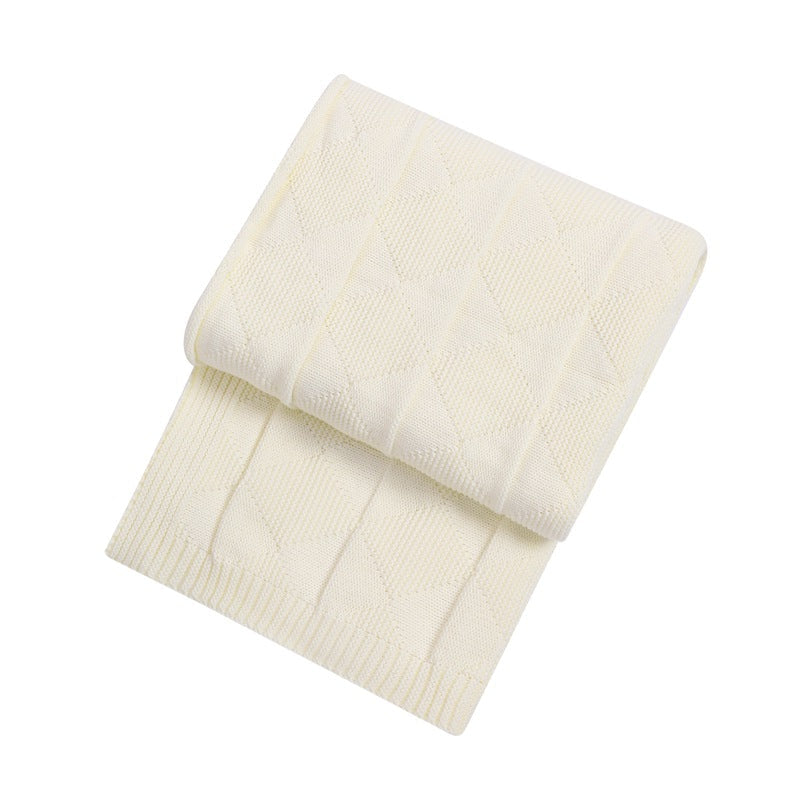Folded cream-colored blanket on a white background
