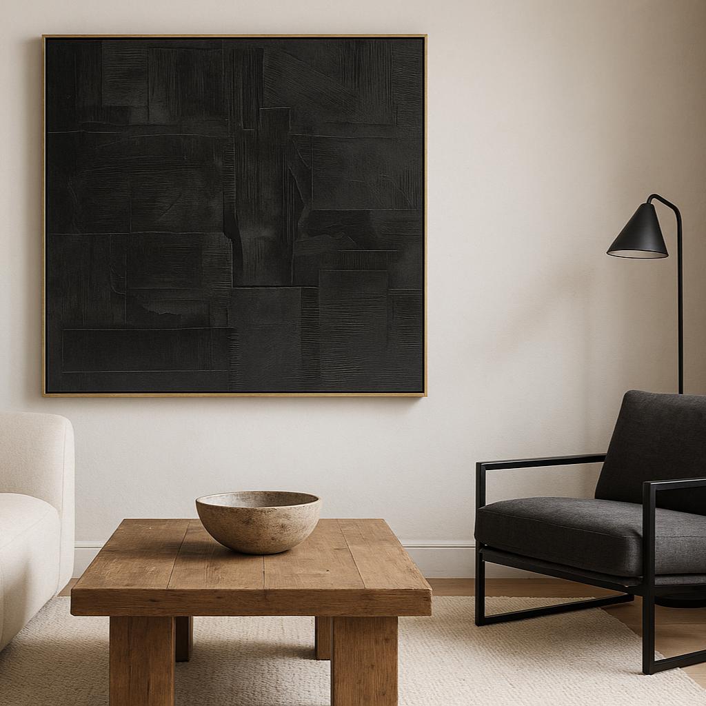Modern living room with a black abstract painting, wooden coffee table, and gray armchair.