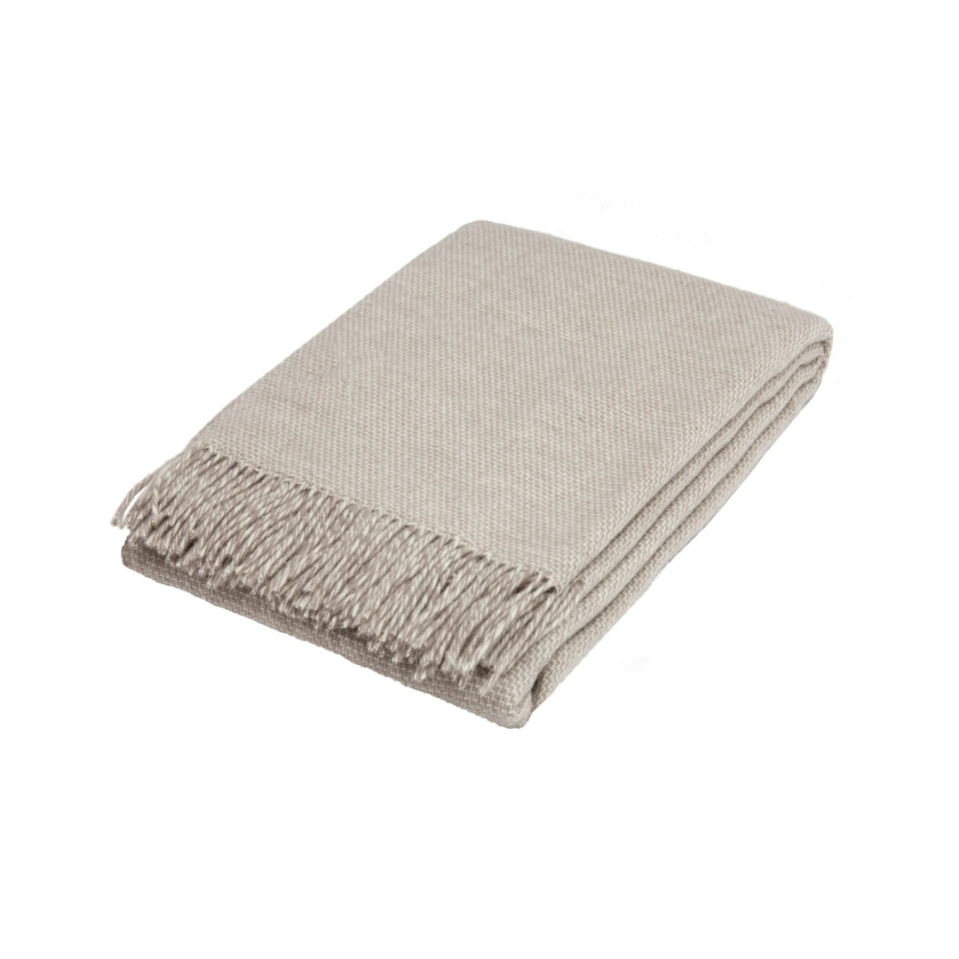 Silver woven blanket with fringes on a white background
