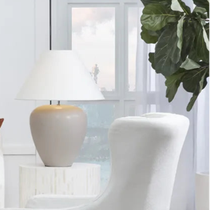 Modern living room with white sofa, armchair, and round coffee table.