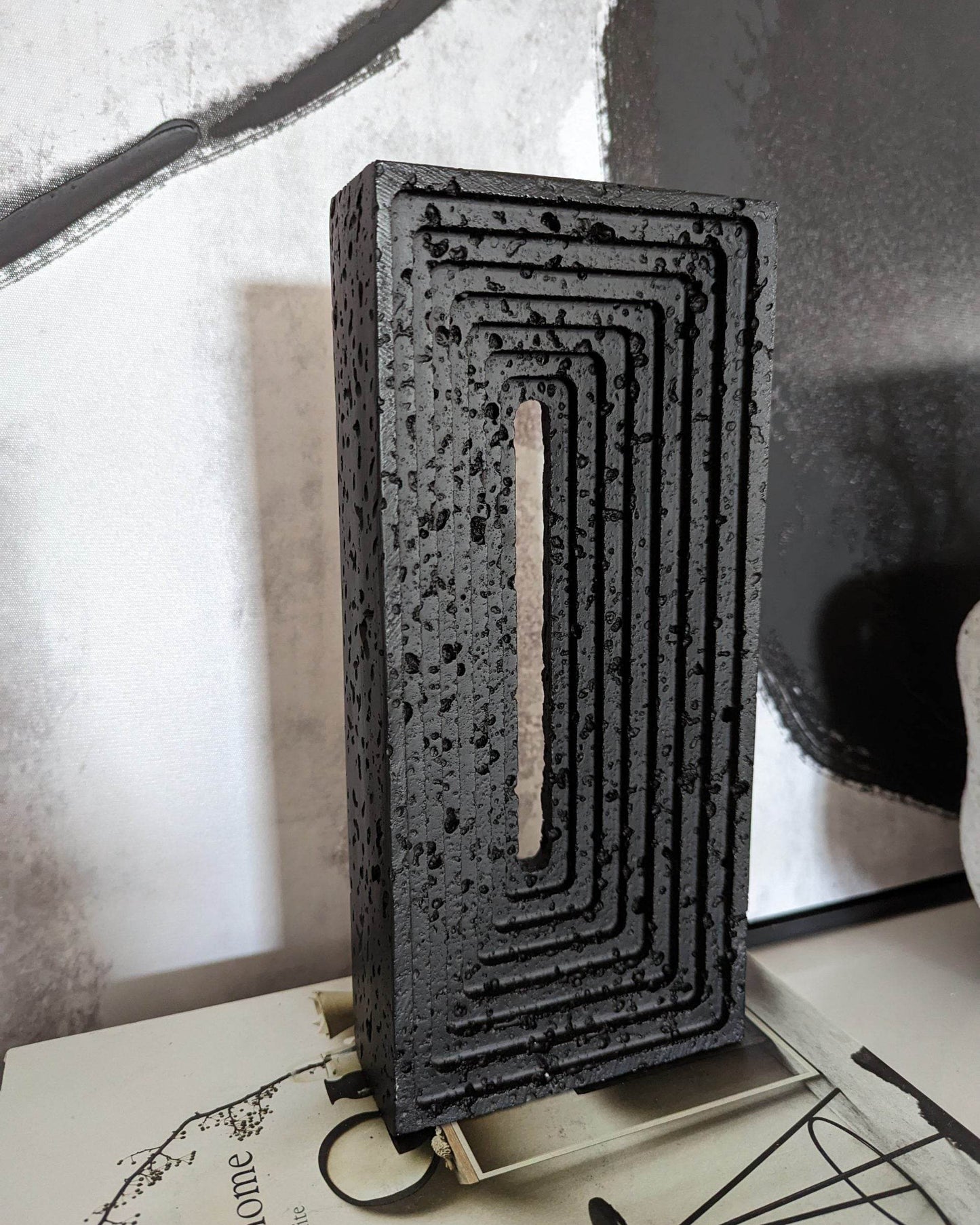 Black Resin Brick Sculpture Styled on Stack of Books on Marble Console Table | Mirra Interiors