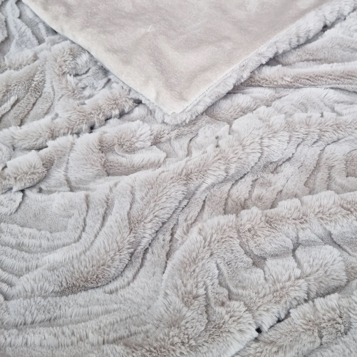 Close-up of a textured light grey blanket with a soft surface.