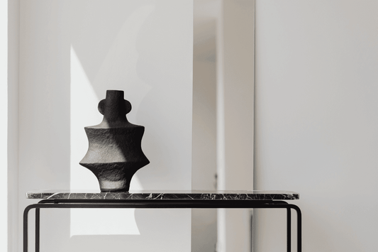 Minimalist console table styling tips featuring a sleek black vase on a modern table
