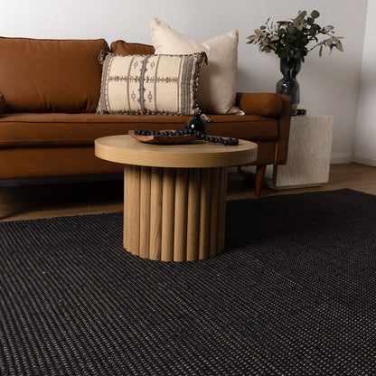 Living room with brown sofa, wooden coffee table, and decorative items.