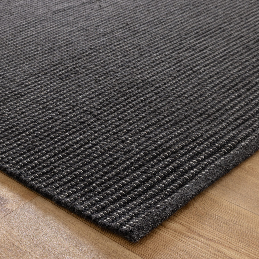 Black rug on a wooden floor