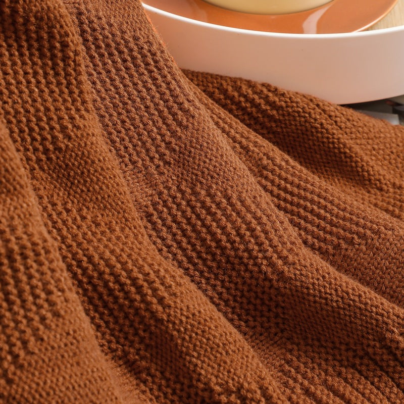 Close-up of a brown textured fabric with a blurred white bowl in the background.