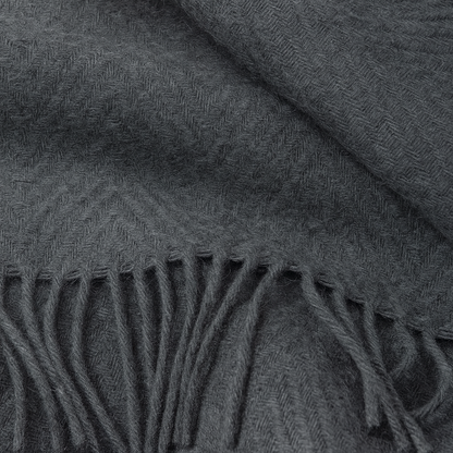 Close-up of a dark gray throw rug with fringed edge