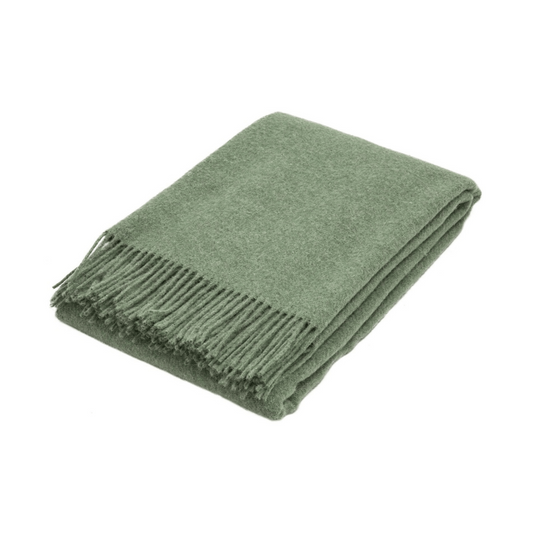 sage green wool throw rug folded on white background | Mirra Interiors