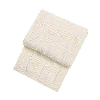 Folded cream-colored blanket on a white background