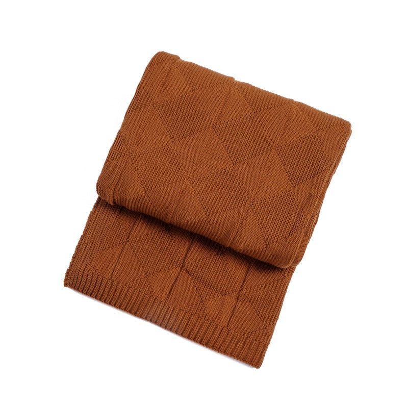 Folded brown knitted blanket on a white background