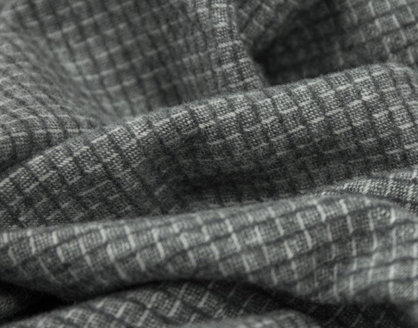 Close-up of textured gray throw blanket with a subtle pattern