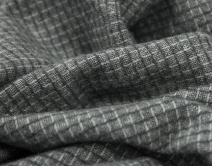 Close-up of textured gray throw blanket with a subtle pattern