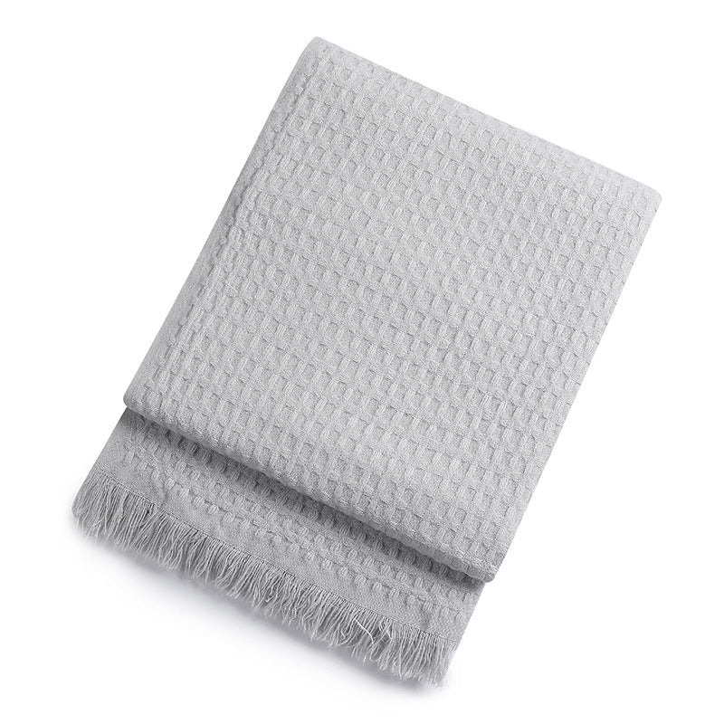 Grey textured throw blanket on a white background