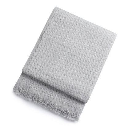 Grey textured throw blanket on a white background
