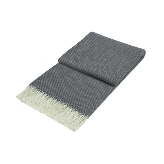 grey wool throw with white fringe detail folded on white background | Mirra Interiors