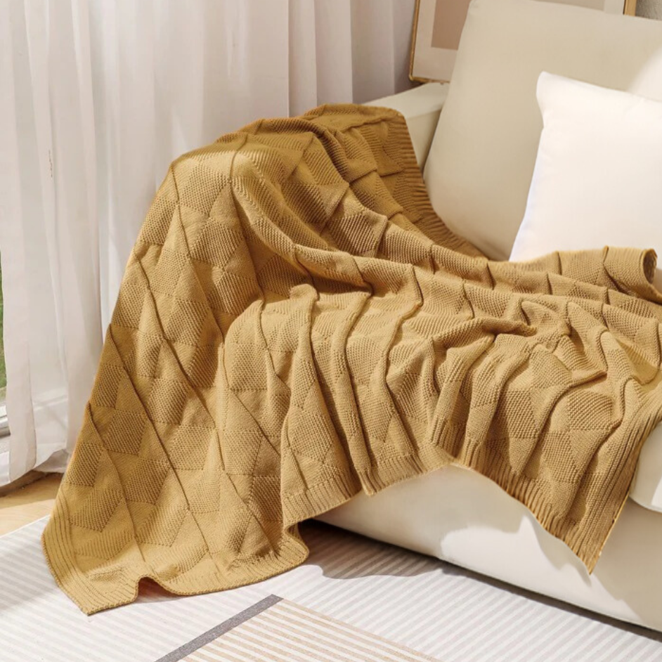 camel acrylic throw rug draped on white sofa