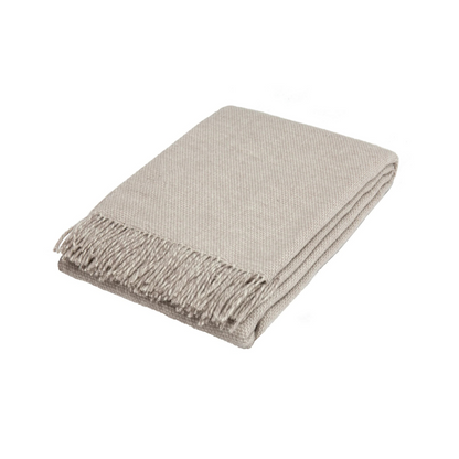 Silver woven blanket with fringes on a white background