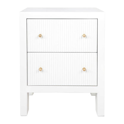 A white fluted bedside table with four drawers and brushed gold handles.