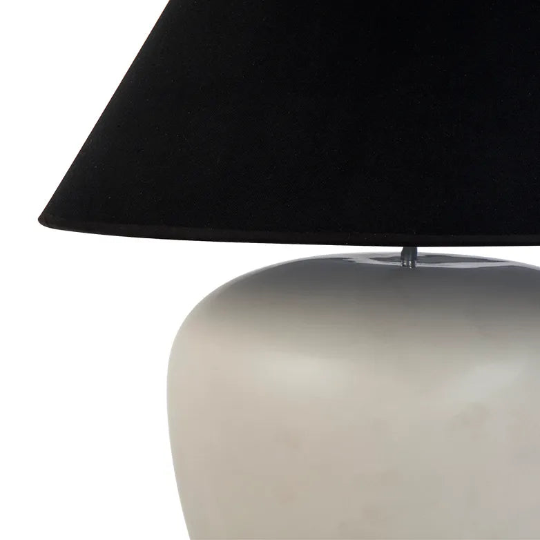 Table lamp with a black shade and white base on a white background
