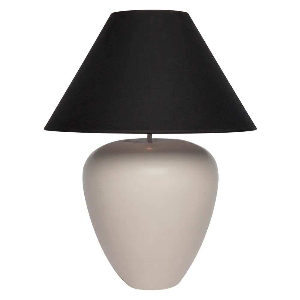 Table lamp with a black shade and beige base on a white background