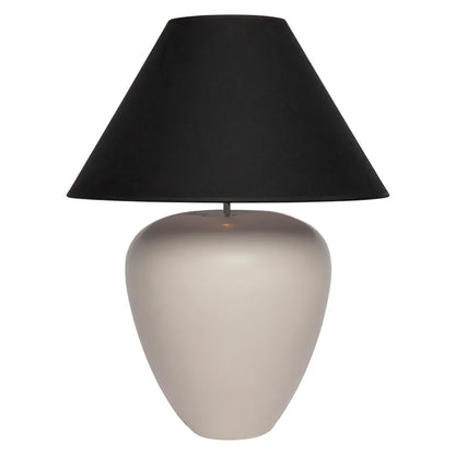 Table lamp with a black shade and beige base on a white background