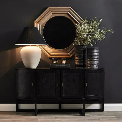 Black wooden sideboard with decorative items against a dark wall