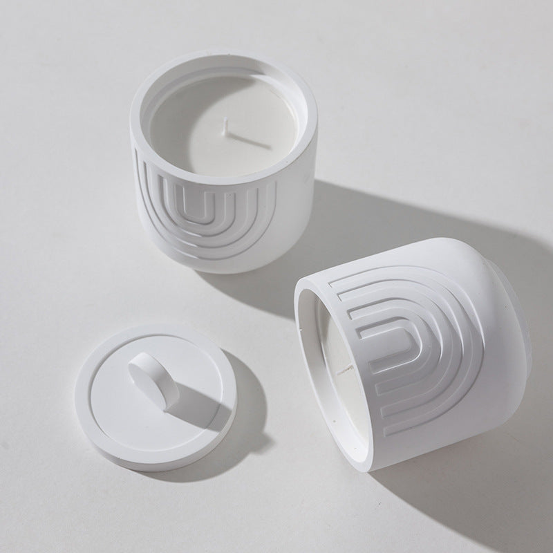 White ceramic containers with geometric design on a light gray background