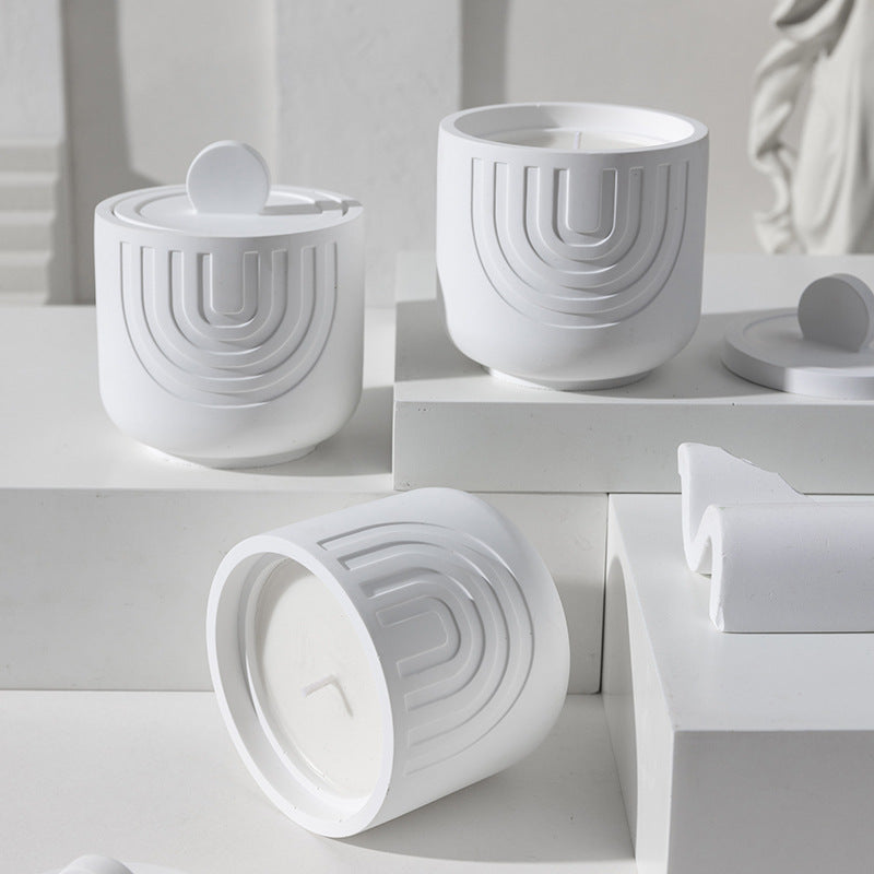 White ceramic containers with geometric design on a white surface