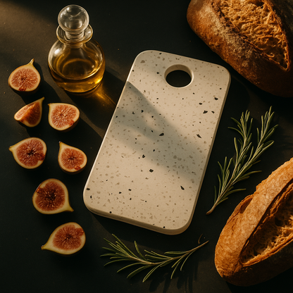 Speckled stone cutting board with figs, bread, and olive oil on a dark surface
