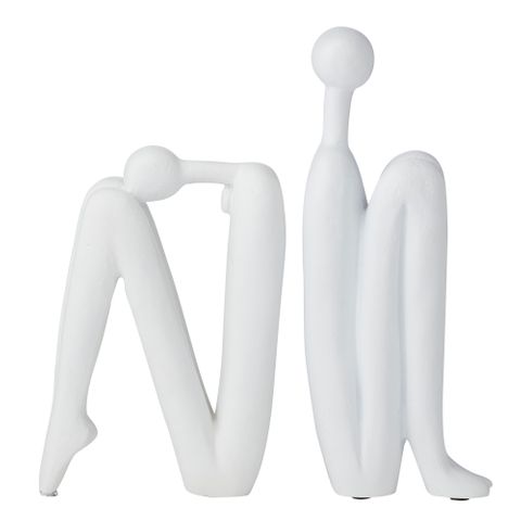 White abstract sculpture of two figures on a white background