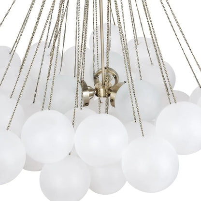 Close-up of a chandelier with white glass balls and brass chains on a white background