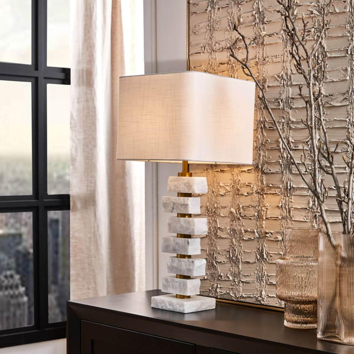 Strata table lamp illuminated on a console