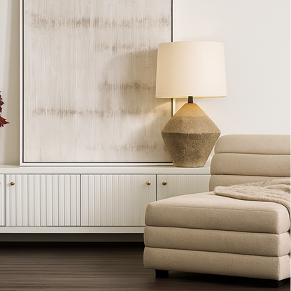 Modern living room with a white cabinet, beige ottoman, and decorative lamp.